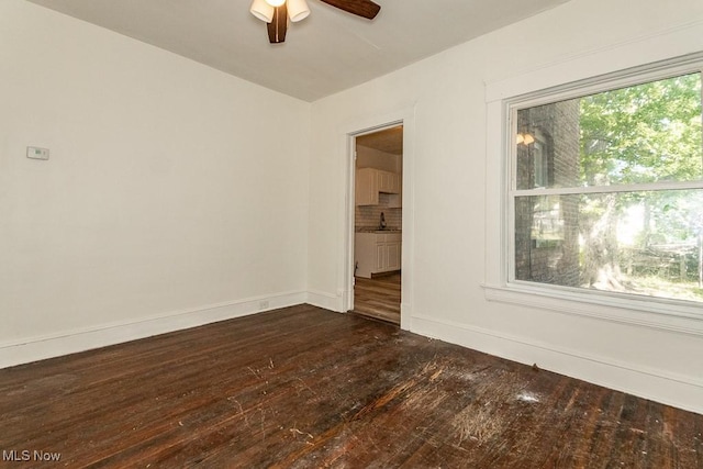 empty room featuring ceiling fan, sink, and dark hardwood / wood-style flooring