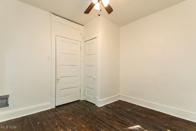 empty room with dark wood-type flooring and ceiling fan