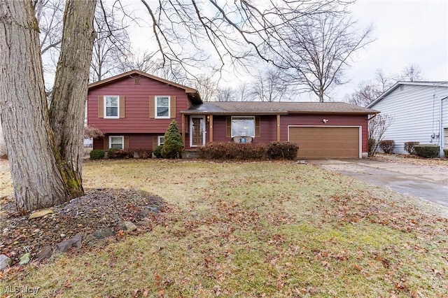 tri-level home featuring a garage and a front lawn