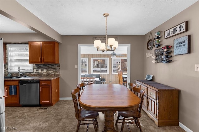 dining space with sink, a notable chandelier, and a textured ceiling