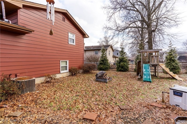 view of side of property featuring a playground and central AC