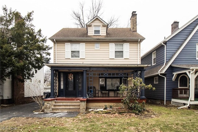 view of front of house with covered porch and a front yard