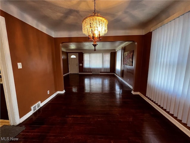 corridor featuring dark wood-type flooring and a chandelier