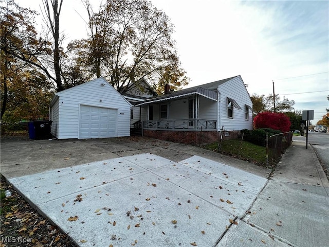 view of front facade featuring a garage, an outdoor structure, and a porch