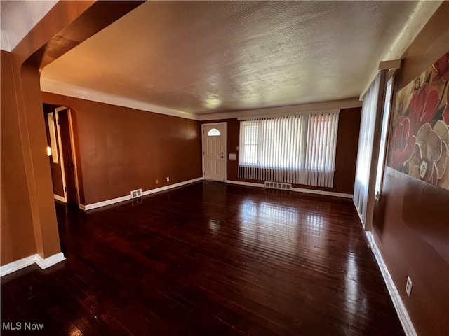 interior space featuring dark wood-type flooring and a textured ceiling