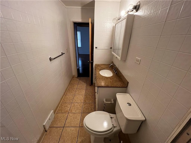 bathroom featuring tile patterned flooring, vanity, and tile walls