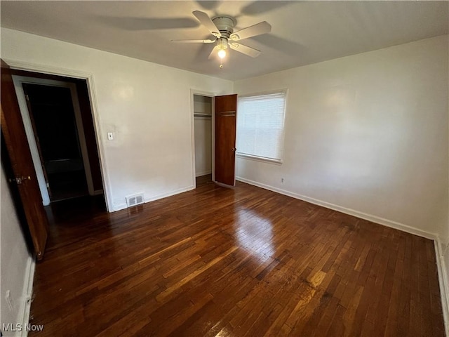 unfurnished bedroom featuring dark hardwood / wood-style floors, ceiling fan, and a closet