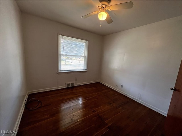 empty room featuring dark wood-type flooring and ceiling fan