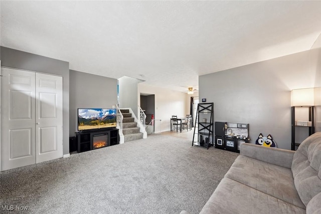 living room featuring ceiling fan and carpet