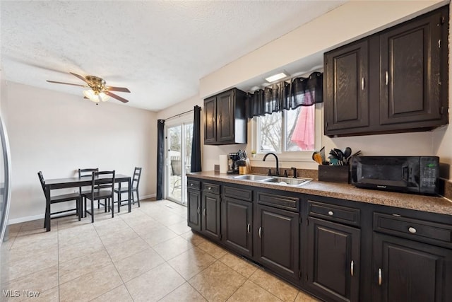 kitchen with ceiling fan, sink, a textured ceiling, and light tile patterned floors