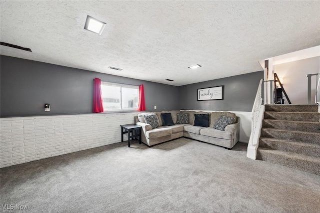 living room with brick wall, a textured ceiling, and carpet flooring