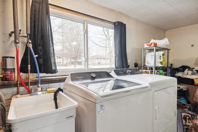 clothes washing area with sink and washer and clothes dryer