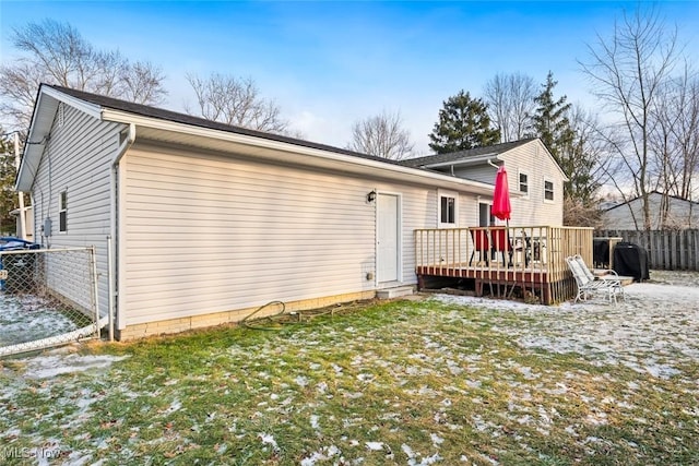 rear view of house with a lawn and a deck