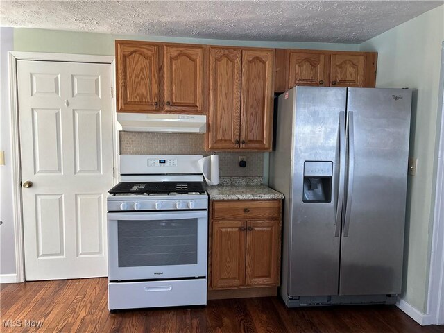 kitchen with backsplash, dark hardwood / wood-style floors, stainless steel refrigerator with ice dispenser, a textured ceiling, and white gas stove