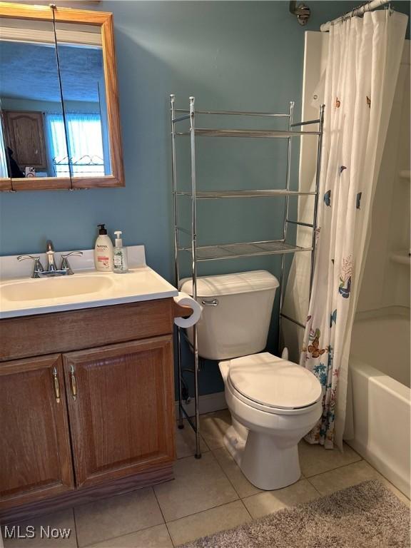 full bathroom featuring vanity, tile patterned floors, toilet, and shower / bath combo