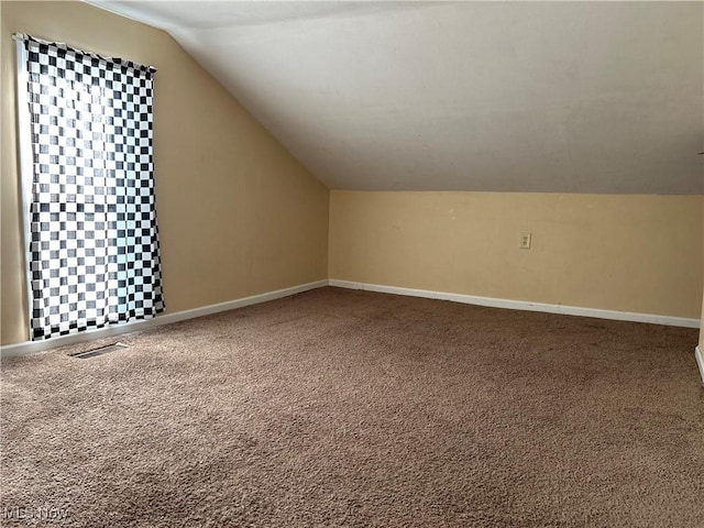 bonus room featuring lofted ceiling and carpet floors