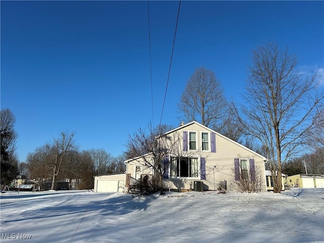 front of property with a garage and central air condition unit