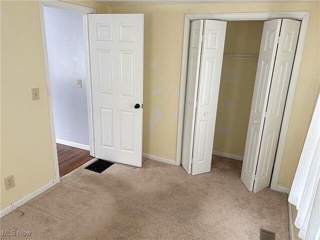 unfurnished bedroom featuring carpet floors and a closet