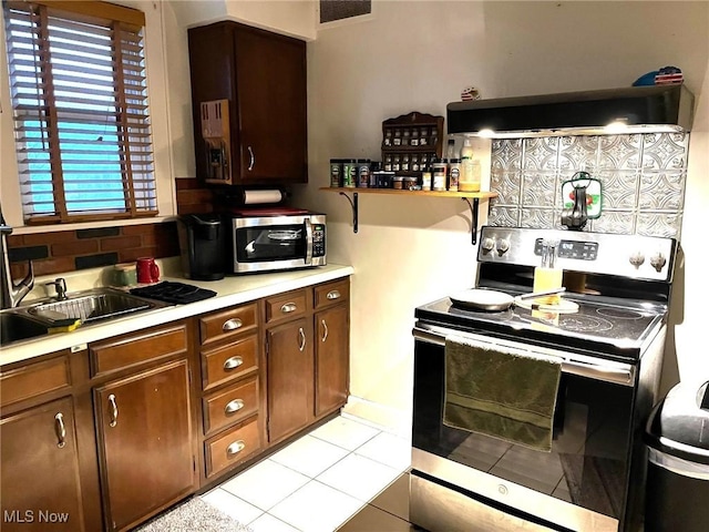 kitchen featuring visible vents, exhaust hood, stainless steel appliances, light countertops, and light tile patterned flooring