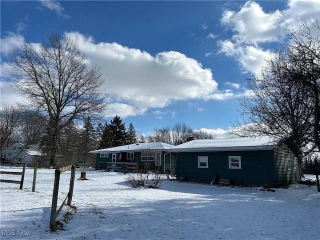 view of snow covered back of property