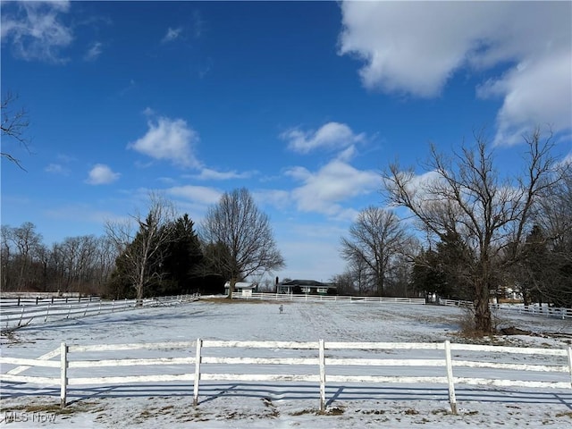 yard layered in snow featuring a rural view