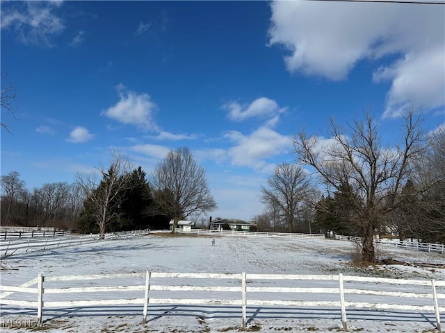 yard covered in snow with a rural view