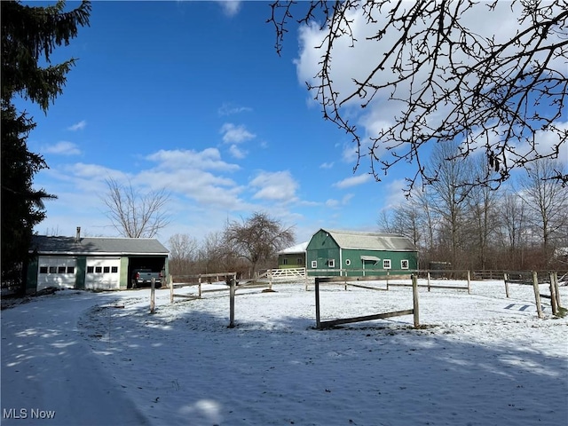 yard covered in snow with a garage and an outbuilding