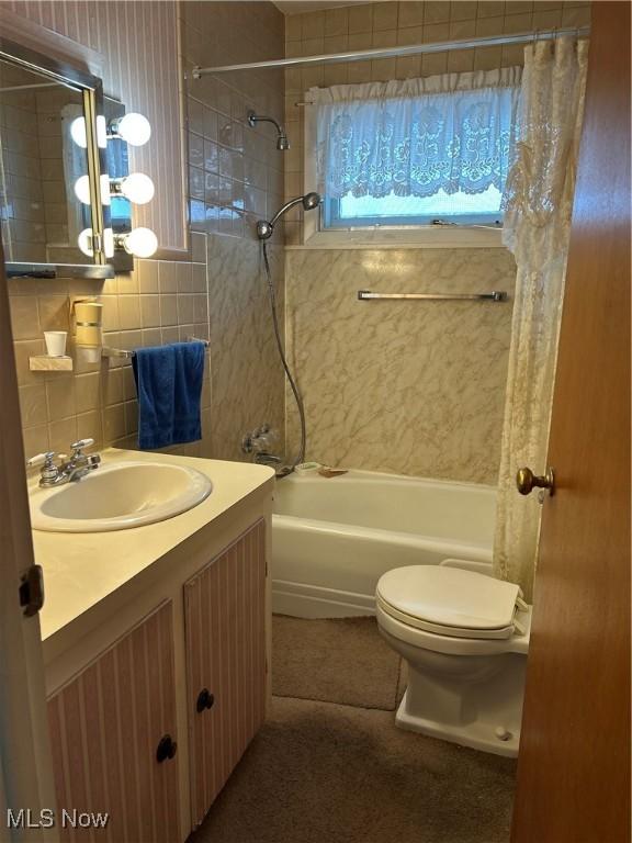 full bathroom featuring shower / tub combo with curtain, toilet, tasteful backsplash, tile walls, and vanity