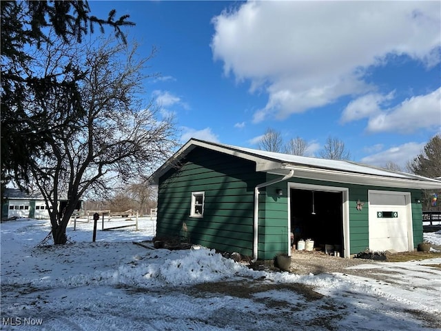 snow covered structure featuring a garage