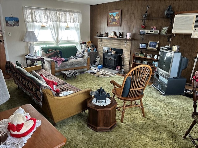 living room with carpet floors, a wood stove, and wood walls