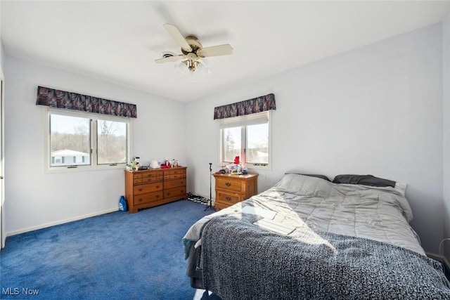 carpeted bedroom featuring multiple windows and ceiling fan