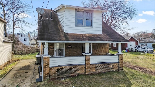 rear view of property featuring a porch and a yard