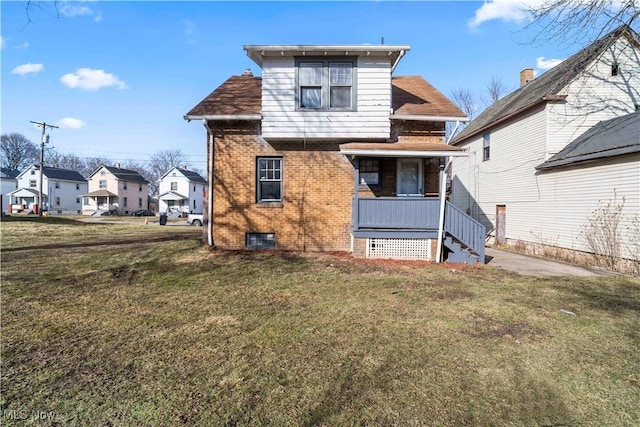 rear view of property with a lawn and a porch