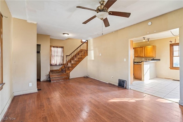 unfurnished living room featuring ceiling fan and light hardwood / wood-style flooring