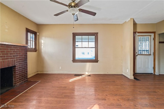 unfurnished living room with wood-type flooring, ceiling fan, and a fireplace