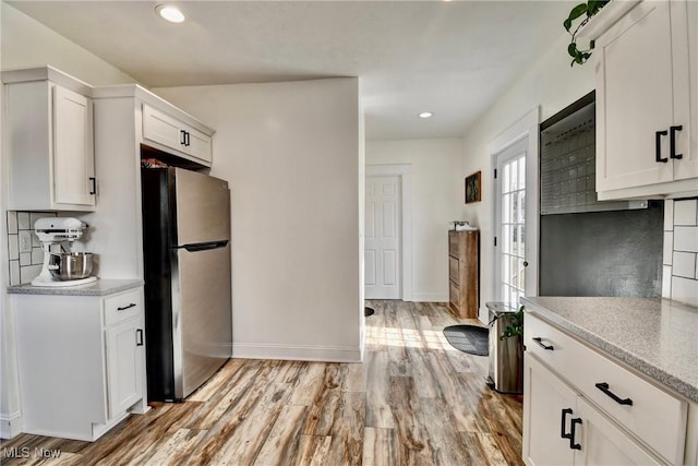 kitchen featuring white cabinetry, stainless steel fridge, and light hardwood / wood-style flooring