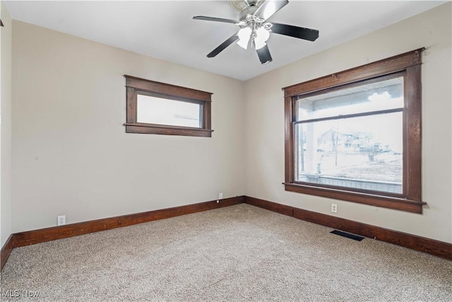 carpeted spare room featuring ceiling fan