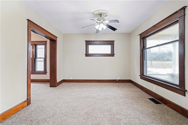 empty room with ceiling fan and light carpet