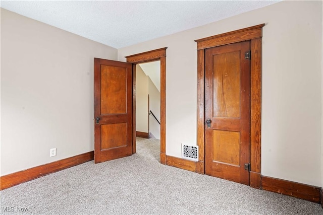 unfurnished bedroom with light carpet and a textured ceiling