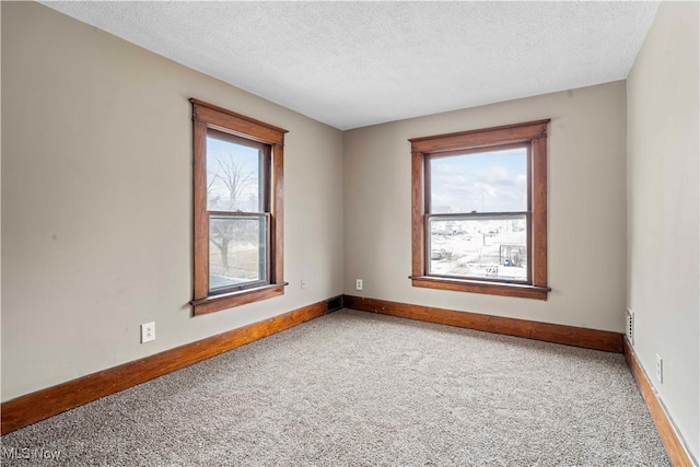 carpeted spare room with a textured ceiling