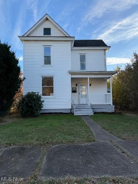 view of property with a porch and a front yard