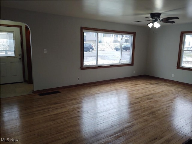 interior space featuring wood-type flooring, a healthy amount of sunlight, and ceiling fan