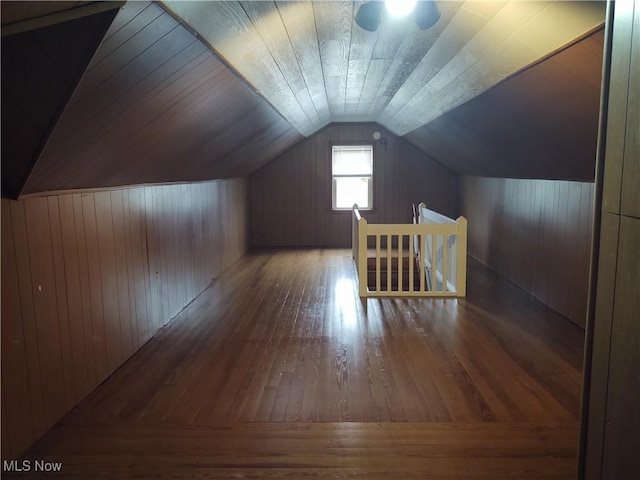 bonus room featuring lofted ceiling, wood-type flooring, and wood walls