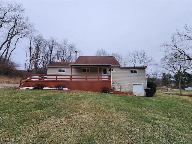 back of house with a wooden deck and a yard