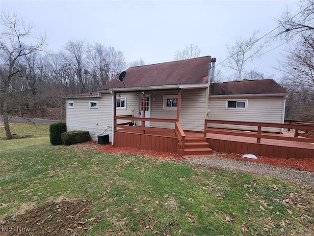 back of property featuring a wooden deck and a yard