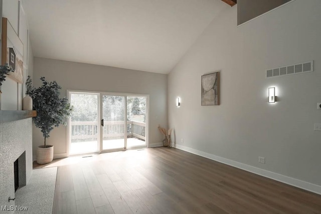 unfurnished living room with hardwood / wood-style flooring and high vaulted ceiling