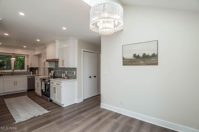 kitchen with premium range hood, appliances with stainless steel finishes, tasteful backsplash, white cabinets, and dark wood-type flooring