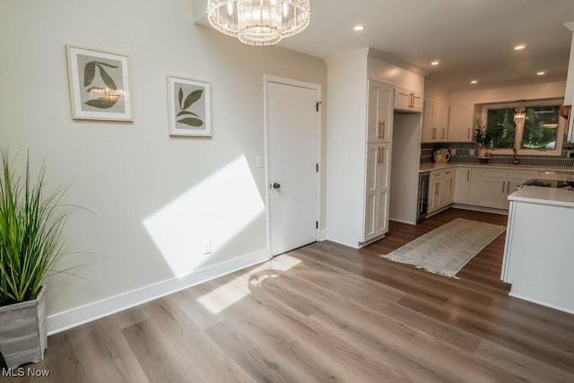 kitchen featuring white cabinetry, beverage cooler, hardwood / wood-style floors, and hanging light fixtures