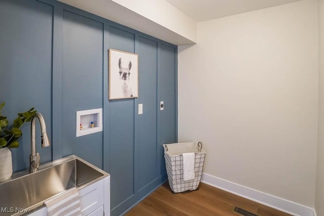 clothes washing area featuring cabinets, washer hookup, dark hardwood / wood-style floors, and sink