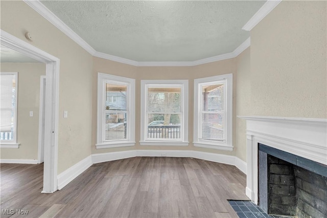 unfurnished living room with hardwood / wood-style floors, crown molding, and a textured ceiling